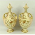 A pair of Royal Worcester blush ivory vases and covers, of small gourd form, on pedestal bases, the ... 