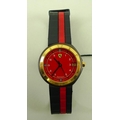 A Ferrari wristwatch, the circular red dial with Arabic numerals, and Ferrari logo and name at 12 an... 