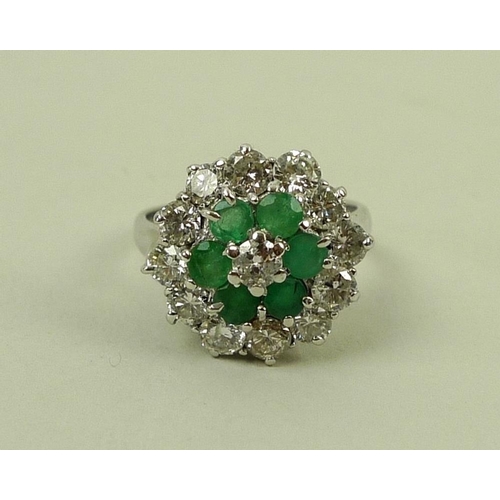 840 - An 18ct white gold, emerald and diamond dress ring, a central diamond surrounded by six emeralds in ... 