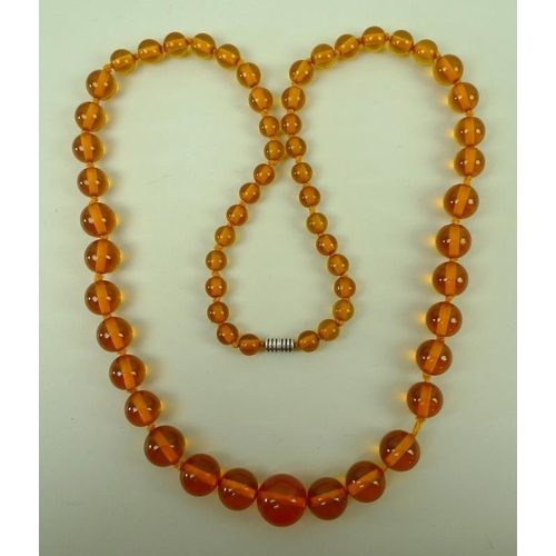 841 - A string of clear honey coloured amber beads of graduated size, 90cm.