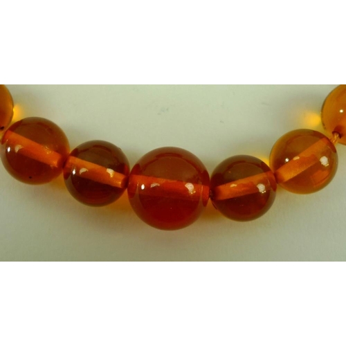 841 - A string of clear honey coloured amber beads of graduated size, 90cm.