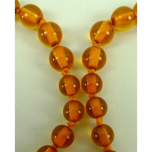 841 - A string of clear honey coloured amber beads of graduated size, 90cm.