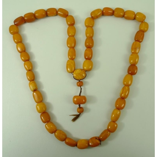 855 - A string of fifty vintage amber worry beads, of butterscotch colour, 79.2g approx, 76cm.