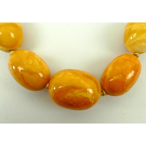 859 - A string of butterscotch coloured amber beads of graduated size, 85g approx, 86cm.