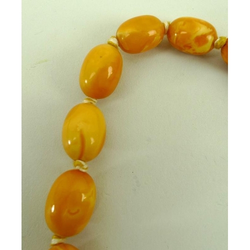 859 - A string of butterscotch coloured amber beads of graduated size, 85g approx, 86cm.