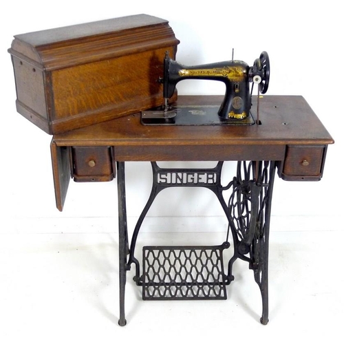 876 - A Singer sewing machine, early 20th century, on oak and cast iron treadle stand with two drawers, oa... 