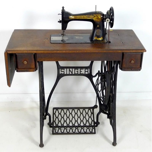 876 - A Singer sewing machine, early 20th century, on oak and cast iron treadle stand with two drawers, oa... 