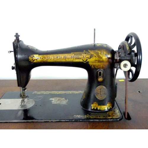 876 - A Singer sewing machine, early 20th century, on oak and cast iron treadle stand with two drawers, oa... 