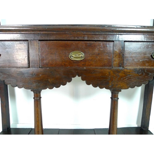 996 - An early Georgian oak dresser and rack of small proportions, with stepped cornice over a shaped frie... 