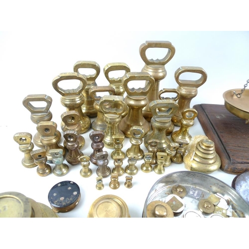 711 - A collection of brass weights, including some sets, a set of R. W. Lomas brass scales on wooden base... 