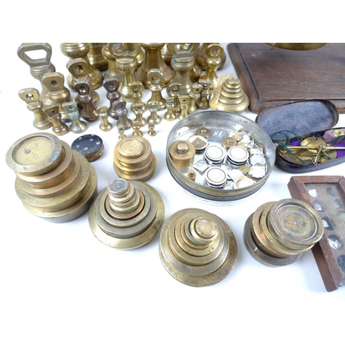 711 - A collection of brass weights, including some sets, a set of R. W. Lomas brass scales on wooden base... 