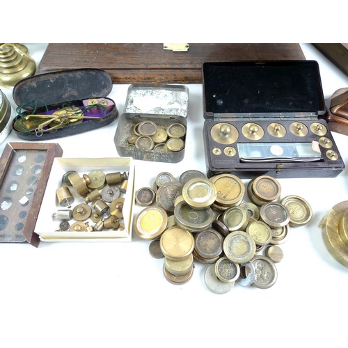 711 - A collection of brass weights, including some sets, a set of R. W. Lomas brass scales on wooden base... 