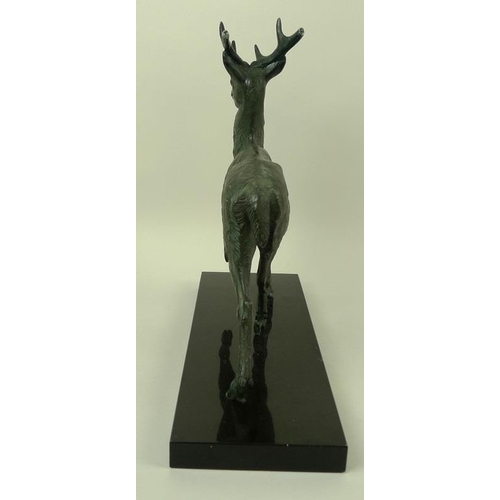 718 - A bronzed pewter figure of a stag, modelled standing, on a black marble base, bears the signature M.... 