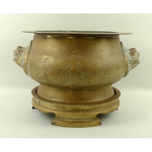 739 - A South East Asian bronze censer on stand, the bulbous body with two lion head handles, one side wit... 