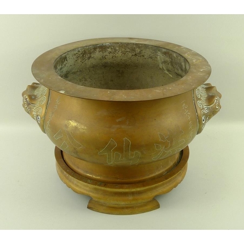 739 - A South East Asian bronze censer on stand, the bulbous body with two lion head handles, one side wit... 