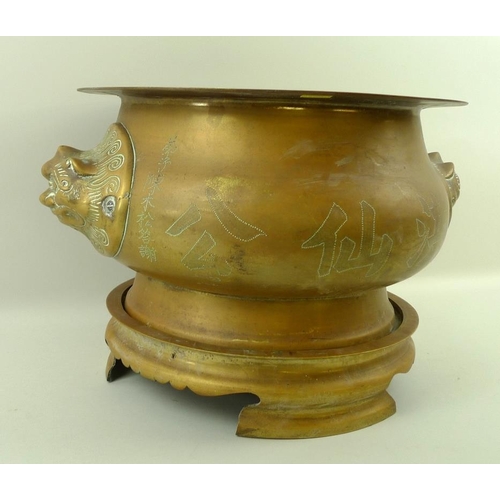 739 - A South East Asian bronze censer on stand, the bulbous body with two lion head handles, one side wit... 