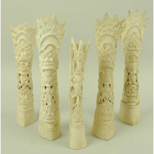 751 - A collection of five bone carvings, comprising four pierced and carved tribal totems, together with ... 