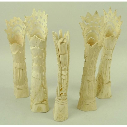 751 - A collection of five bone carvings, comprising four pierced and carved tribal totems, together with ... 