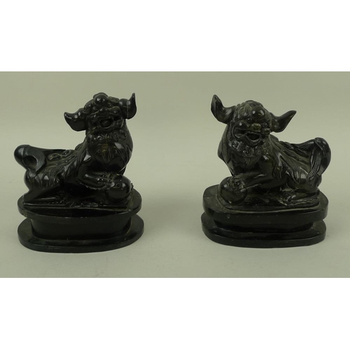 756 - A pair of Chinese carved black hardstone figures of Buddhistic lion dogs, 19th century, carved with ... 