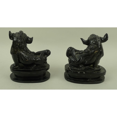 756 - A pair of Chinese carved black hardstone figures of Buddhistic lion dogs, 19th century, carved with ... 