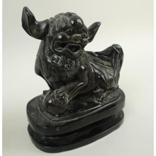 756 - A pair of Chinese carved black hardstone figures of Buddhistic lion dogs, 19th century, carved with ... 