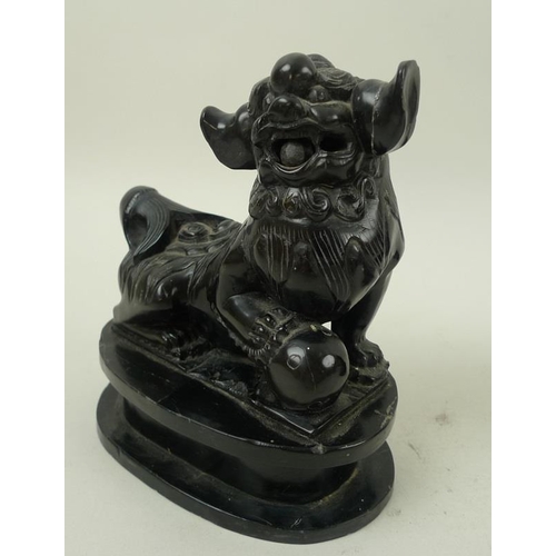 756 - A pair of Chinese carved black hardstone figures of Buddhistic lion dogs, 19th century, carved with ... 