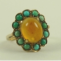A 9ct gold flower ring, the central amber coloured cabochon surrounded by turquoises, size N, 3.6g.
