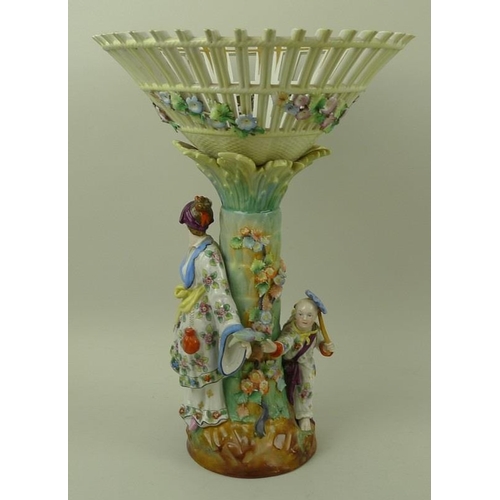 503 - An Art Deco porcelain figural centrepiece, with pierced conical basket on a palm tree column and two... 