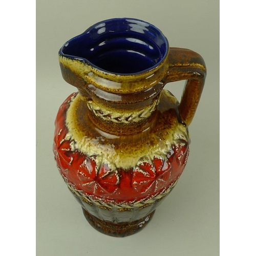 519 - A large West German jug or pitcher with yellow, brown, and red glazes to the exterior, blue glaze to... 