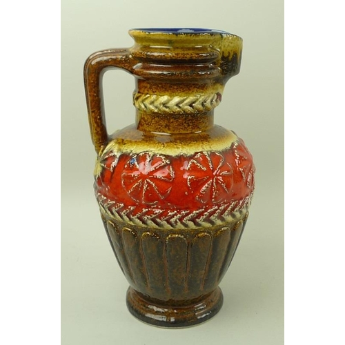 519 - A large West German jug or pitcher with yellow, brown, and red glazes to the exterior, blue glaze to... 