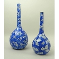 Two Oriental bottle vases, 19th century, with narrow tapering necks, decorated in cobalt blue underg... 