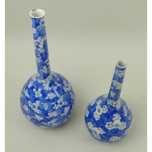 530 - Two Oriental bottle vases, 19th century, with narrow tapering necks, decorated in cobalt blue underg... 