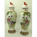 A pair of modern Chinese vases, the bodies decorated with girls strolling arm in arm near a young bo... 