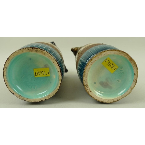 536 - A pair of ceramic Egyptian revival vases with rams head handles, decorated in bands with hieroglyphs... 