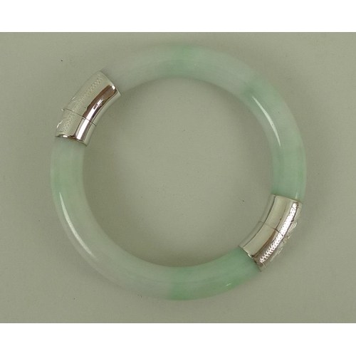 811 - A modern jade bangle, mounted with 14ct white gold engraved hinge and clasp, with safety chain, 6cm ... 