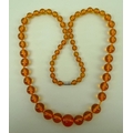 A string of clear honey coloured amber beads of graduated size, 90cm.