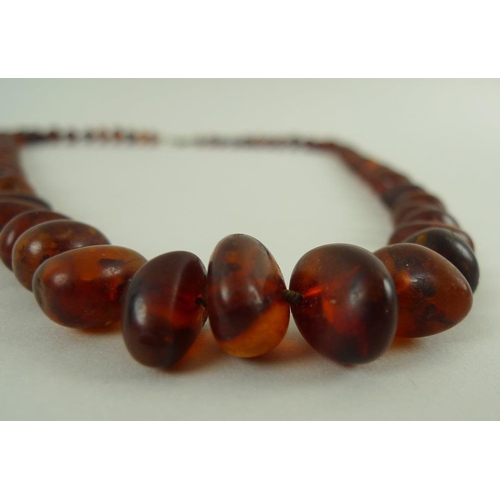 830 - A vintage amber bead necklace, of clear treacle colour with some inclusions, 63cm long, beads gradua... 