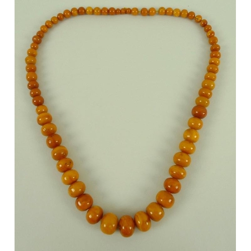 837 - A vintage butterscotch amber bead necklace, 66cm long, beads graduating from 0.6 to 1.8cm, 66.6g.