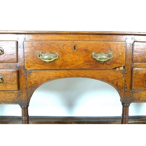 927 - A Georgian oak sideboard, later two shelf plate rack with trefoil detailing to the corners, the base... 