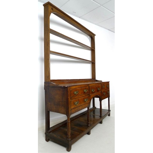 927 - A Georgian oak sideboard, later two shelf plate rack with trefoil detailing to the corners, the base... 