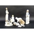 A group of five Lladro figurines, comprising a girl holding a lamp, a seated girl with Arum lilies, ... 