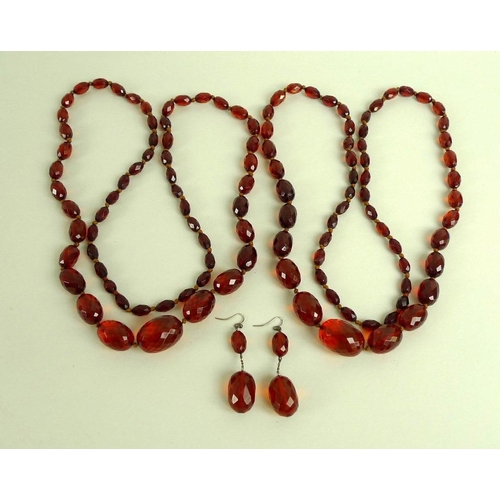 825 - A pair of vintage facet cut amber bead necklaces, circa 1910, of graduated, oval, red treacle colour... 