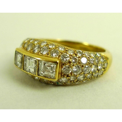 836 - An 18ct gold and diamond modern designed dress ring, of three emerald cut diamonds raised above a di... 