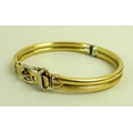A 14ct gold bangle with belt buckle clasp, 7 by 6cm diameter, 20.2g.