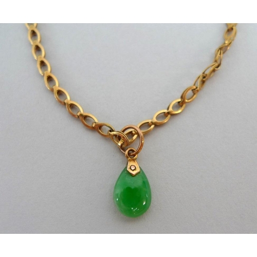 855 - A 14ct gold and jade bracelet, the tear drop jade suspended on a link chain stamped '585 Brev', ston... 