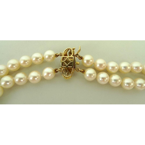 858 - A double strand of 128 pearls, set on a 15ct gold clasp with pave  set diamonds, 47cm long, together... 