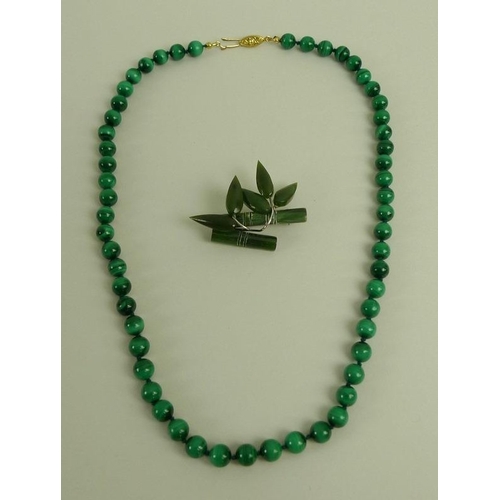 865 - A malachite bead necklace, 54cm long, bead diameter 8mm, with yellow metal clasp, together with an o... 