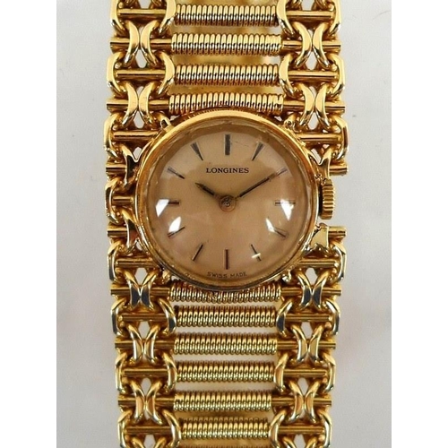 880 - A Longines lady's 18K gold cased wristwatch, champagne enamel circular dial bearing gilt batons, ref... 