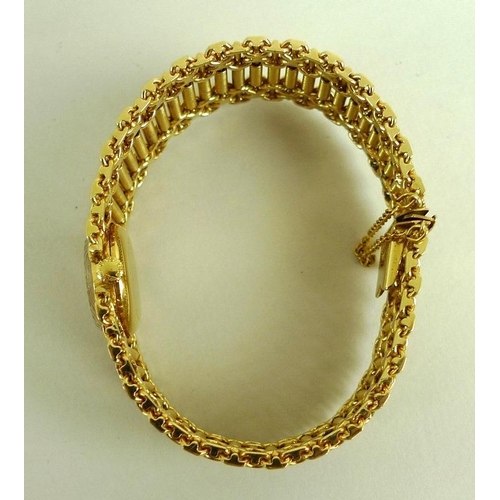 880 - A Longines lady's 18K gold cased wristwatch, champagne enamel circular dial bearing gilt batons, ref... 
