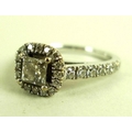 An 18ct gold and diamond ring with central emerald cut diamond of approximately 0.5ct flanked by sev... 
